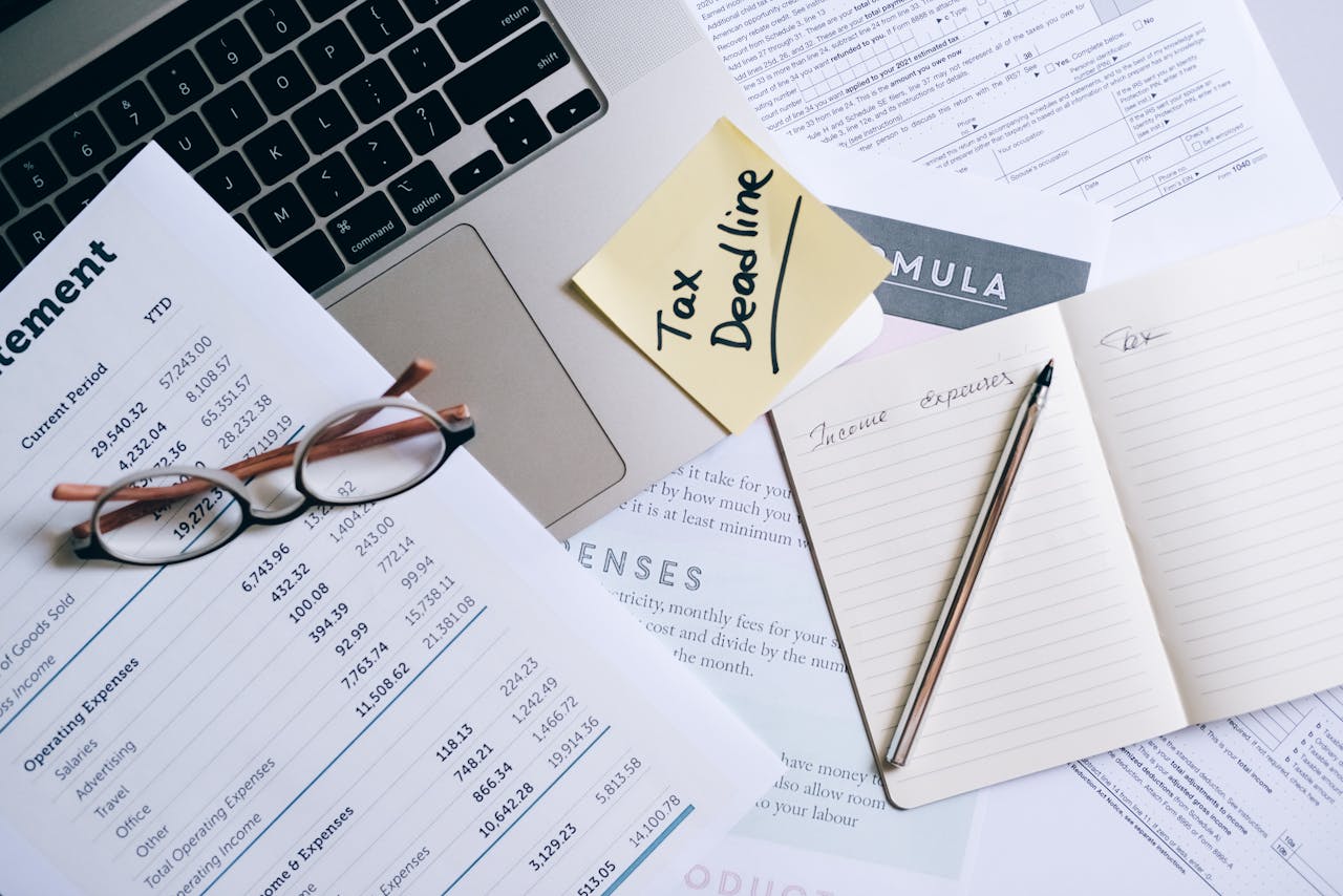 our-story-01 Workspace with laptop, documents, and tax deadline note for financial management.